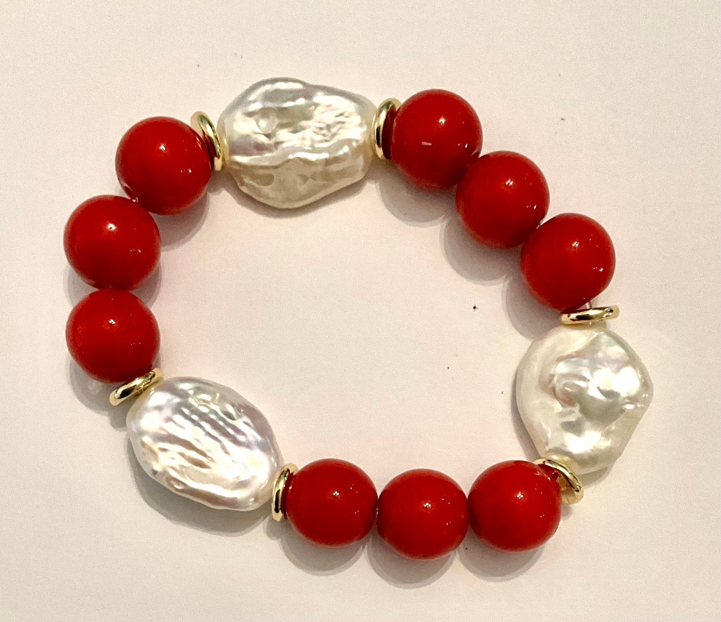 Bracelet with red beads and clear glass pearls on a white background