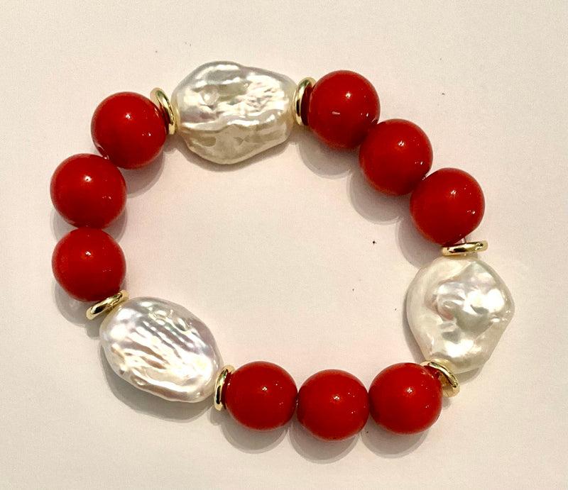 Bracelet with red beads and clear glass pearls on a white background
