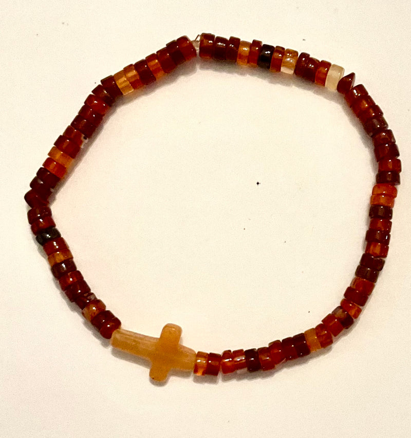 Beaded bracelet with a cross charm on a white background