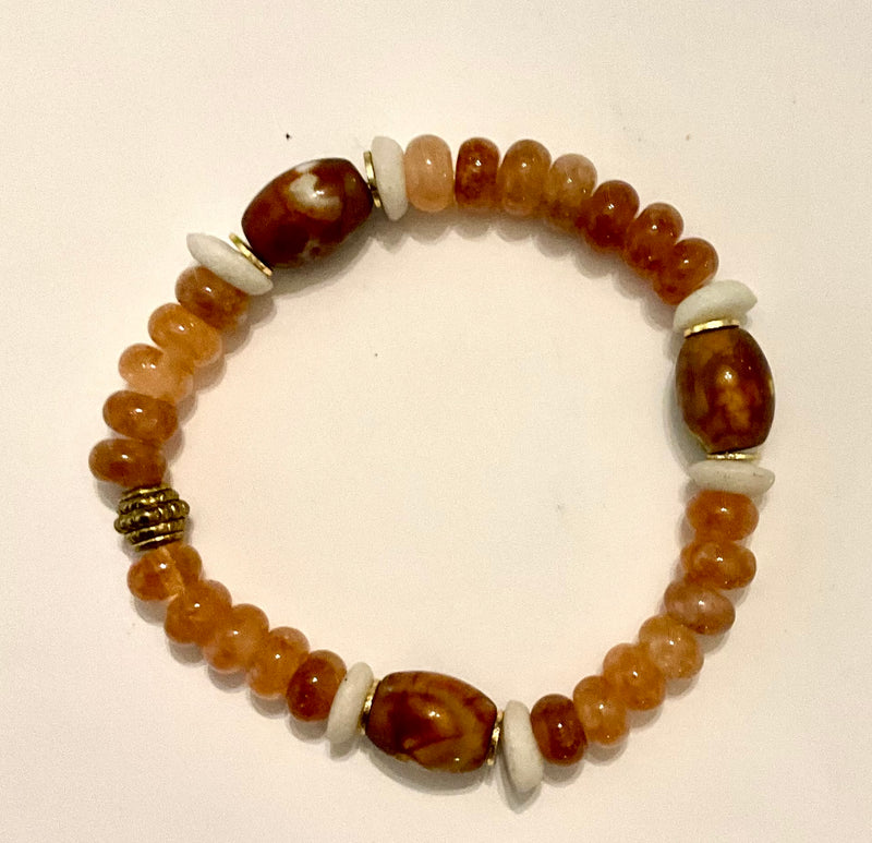 Beaded bracelet with brown, white, and gold beads on a light background