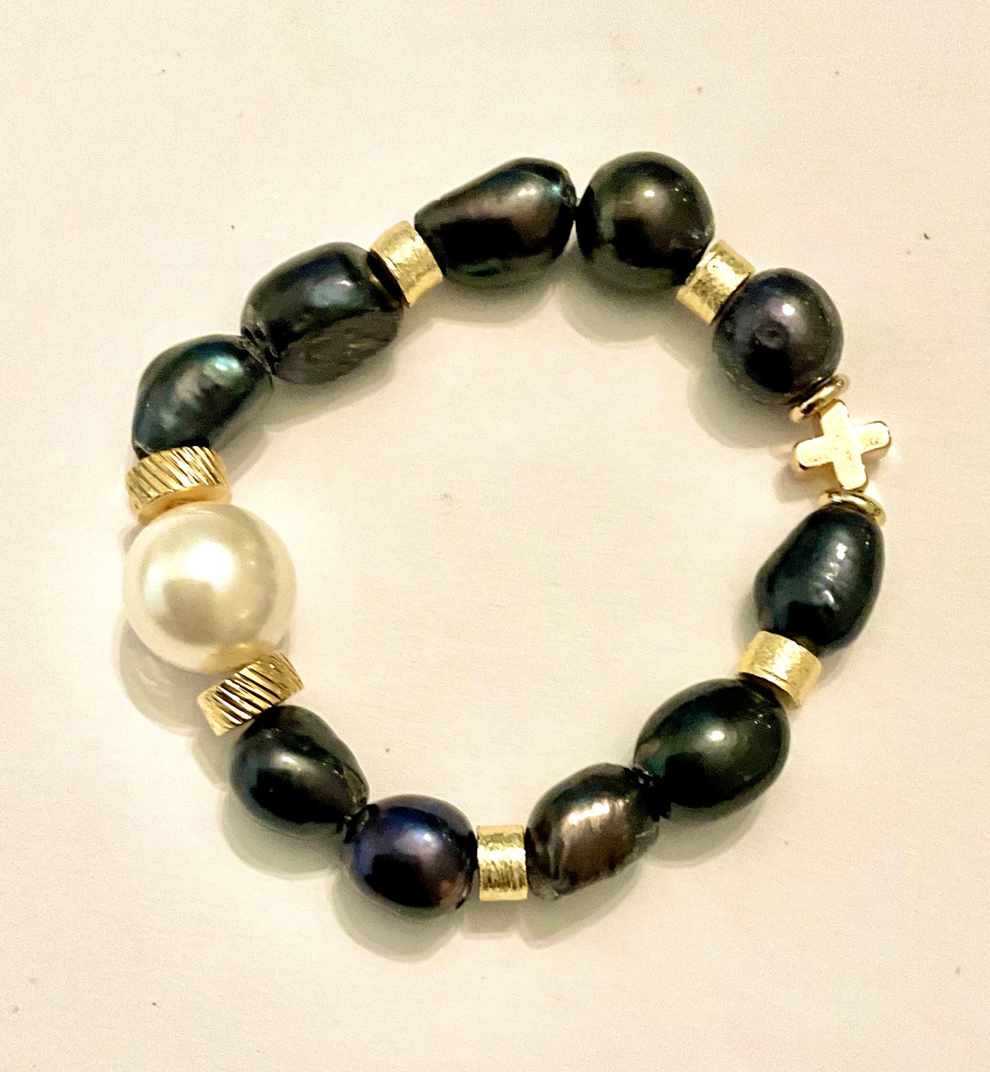 Bracelet with black beads and gold accents on a light background