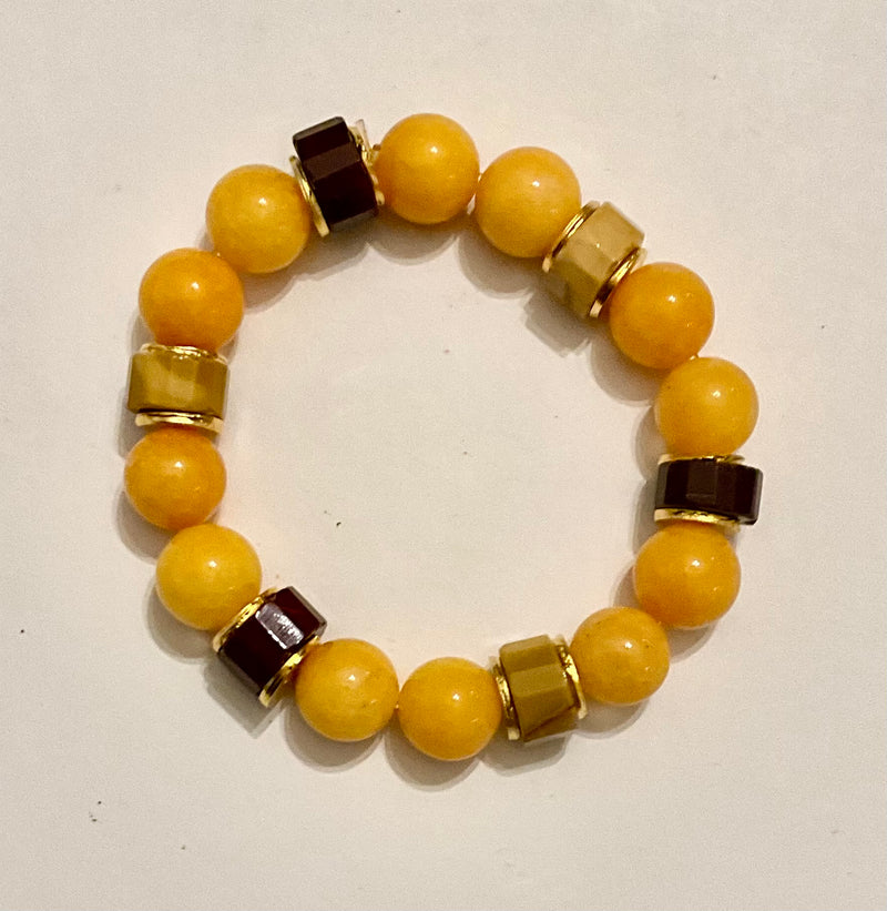 Beaded bracelet with yellow, brown, and gold beads on a white background