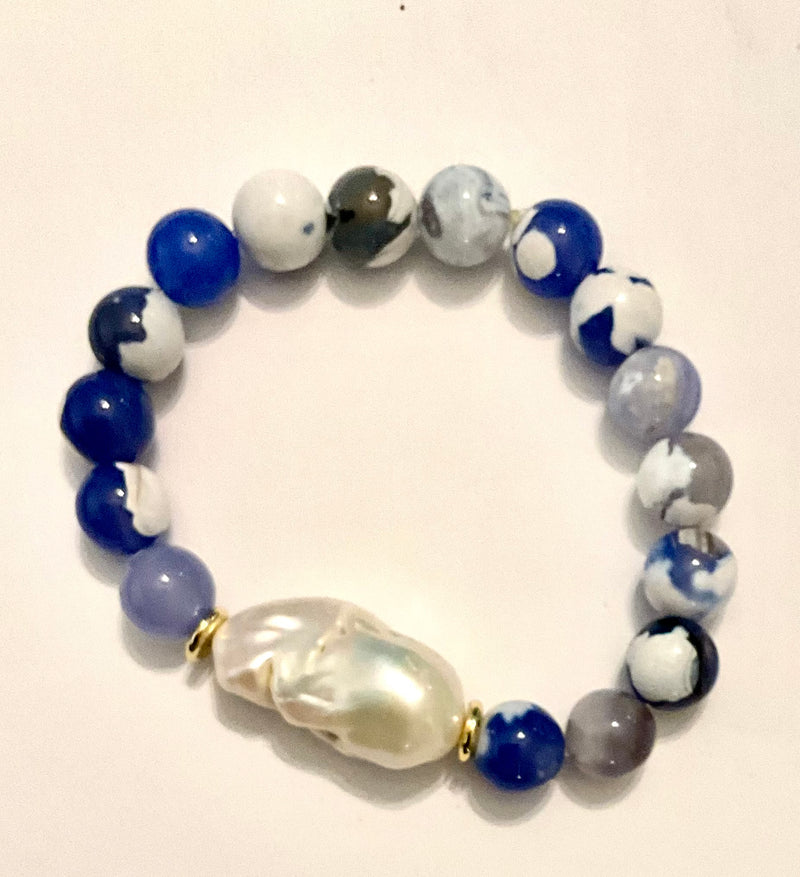 Beaded bracelet with blue, white, and gray marbled beads on a light background