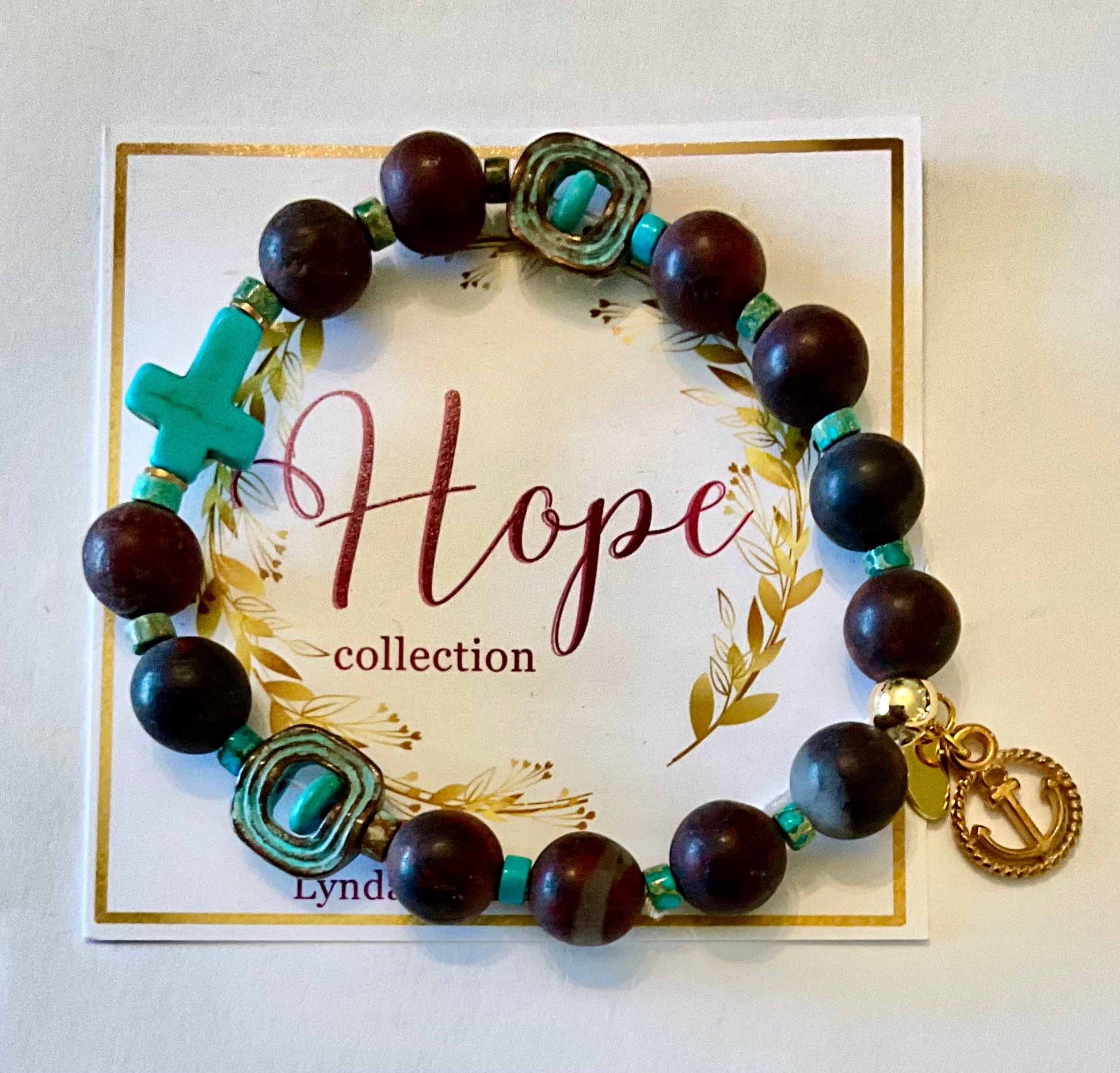 Bracelet with wooden beads and turquoise accents on a 'Hope collection' card.