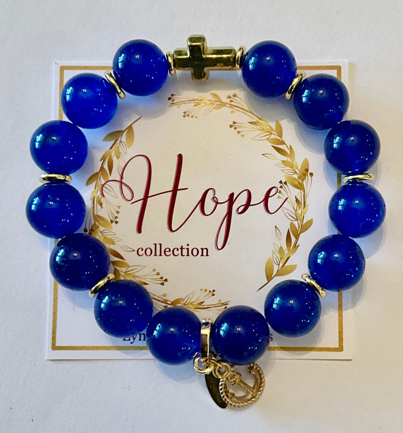 Blue beaded bracelet with a gold charm on a 'Hope collection' card.