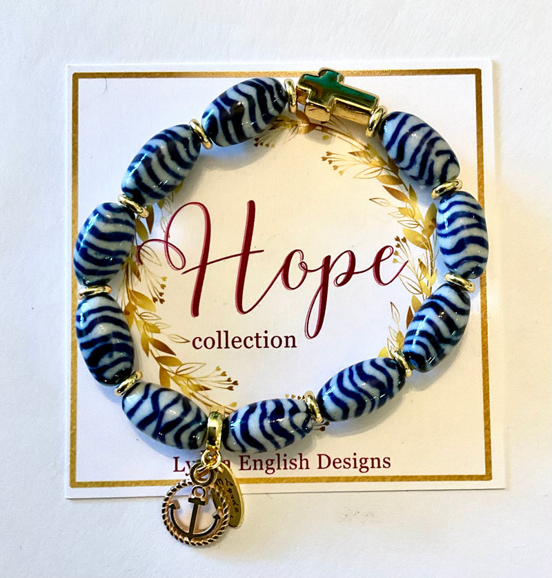 Blue and white beaded bracelet with gold anchor charm on a 'Hope' collection card.