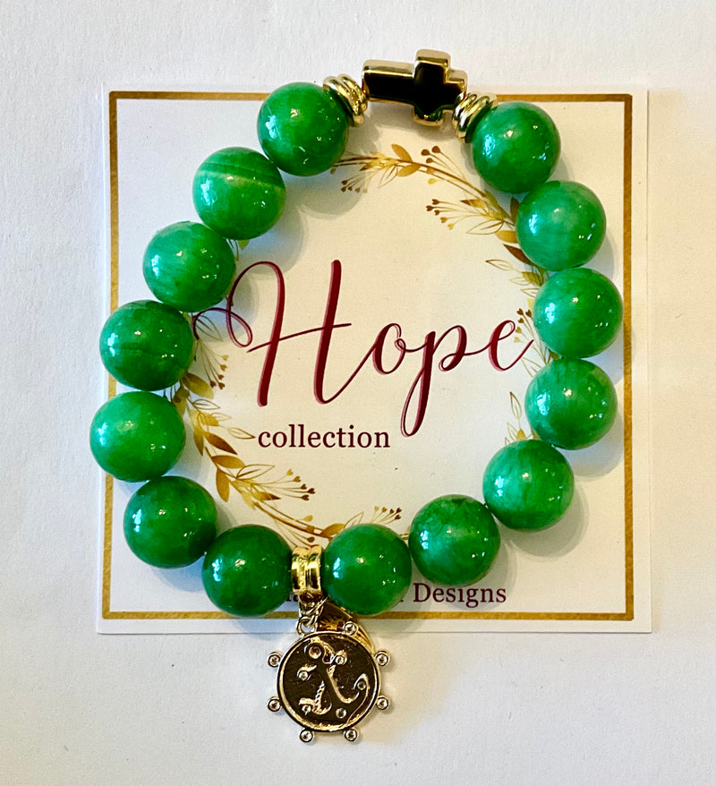 Green beaded bracelet with a gold charm on a 'Hope collection' card.